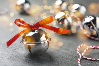 Image of Christmas music. Jingle bells on grey table, bokeh effect