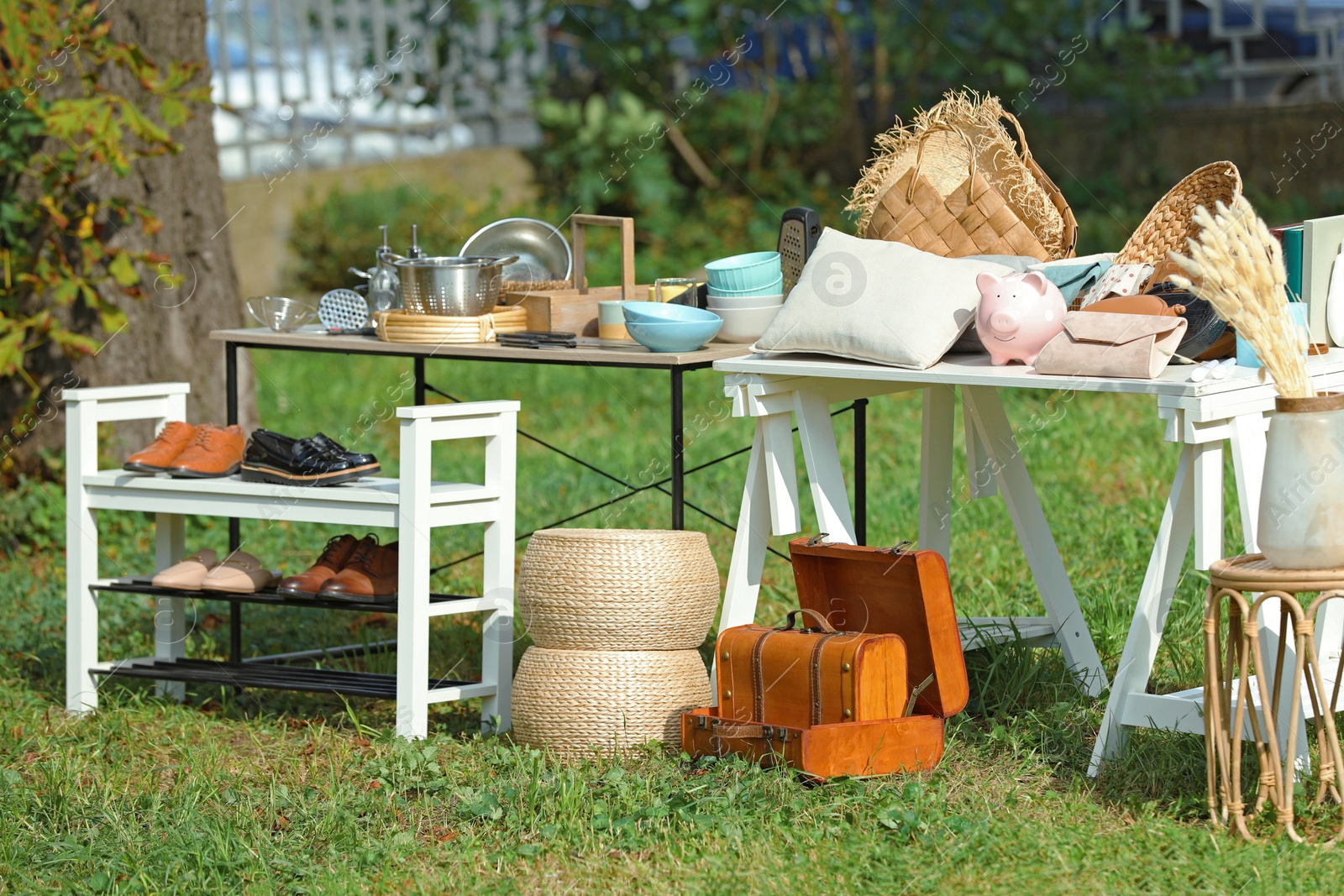 Photo of Small tables with many different items on garage sale in yard