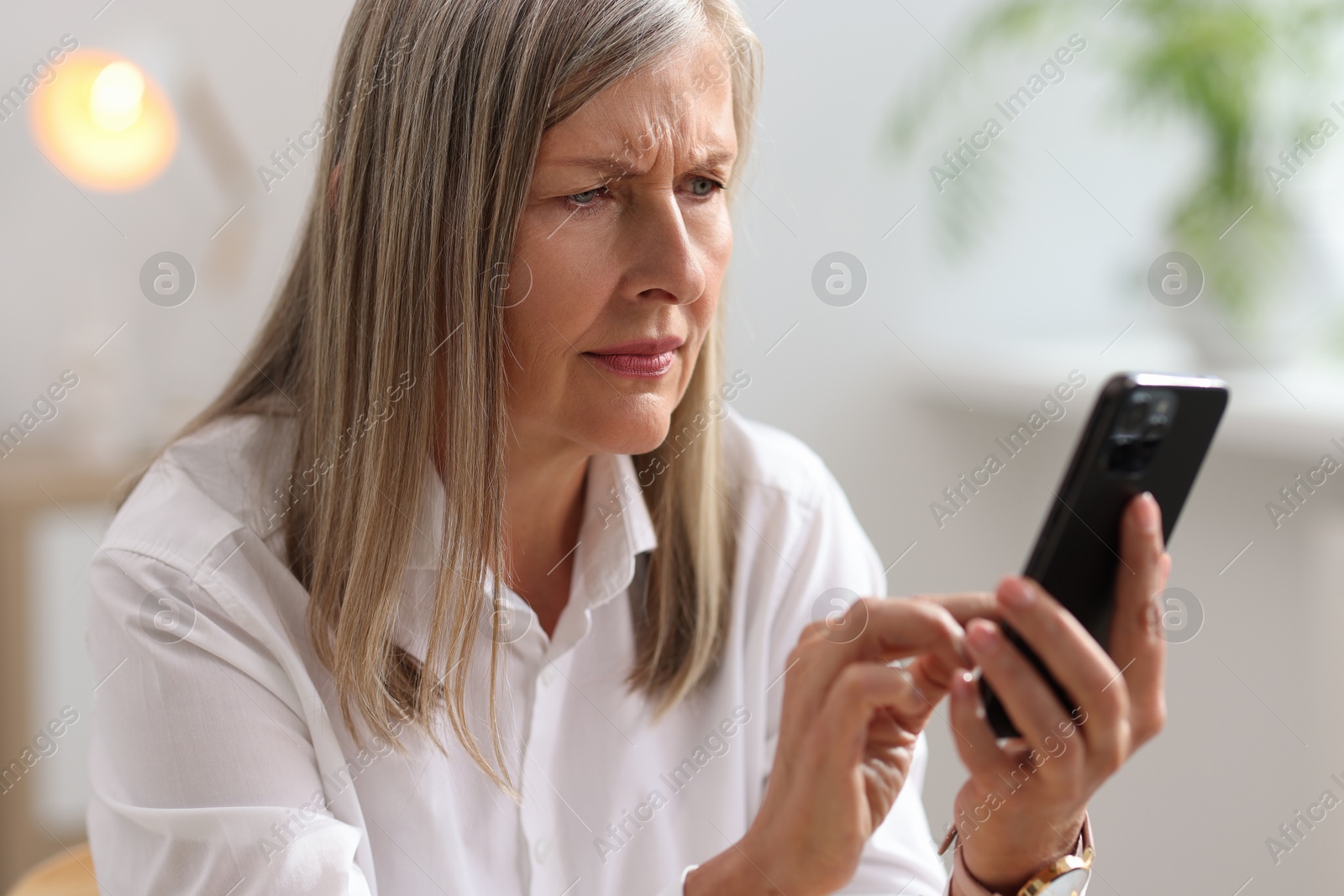 Photo of Senior woman using mobile phone at home