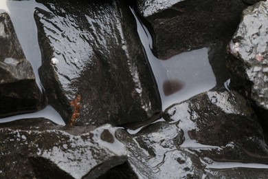 Beautiful pebbles in water as background, top view