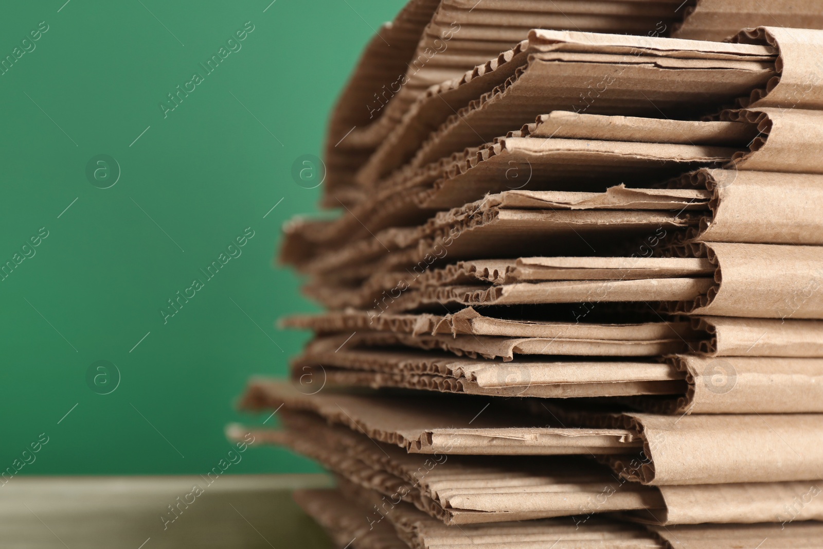 Photo of Cardboard pile on color background, space for text. Waste recycling concept