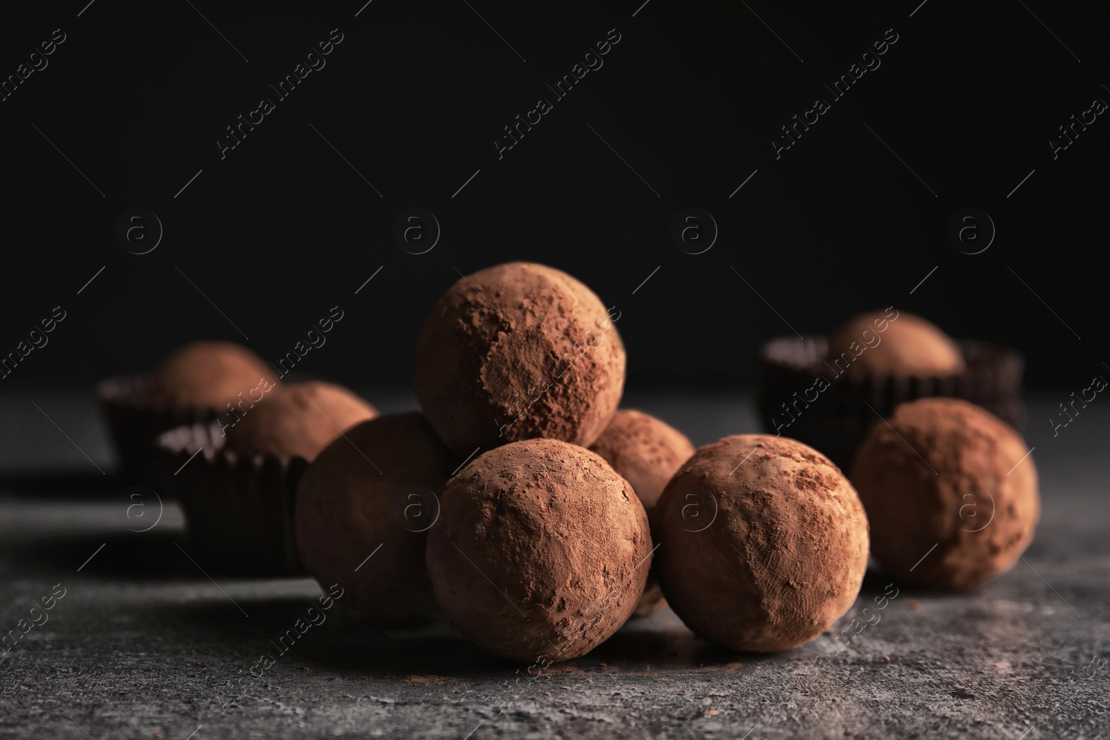 Photo of Tasty raw chocolate truffles on grey table