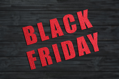 Phrase Black Friday and blurred view of wooden surface on background 