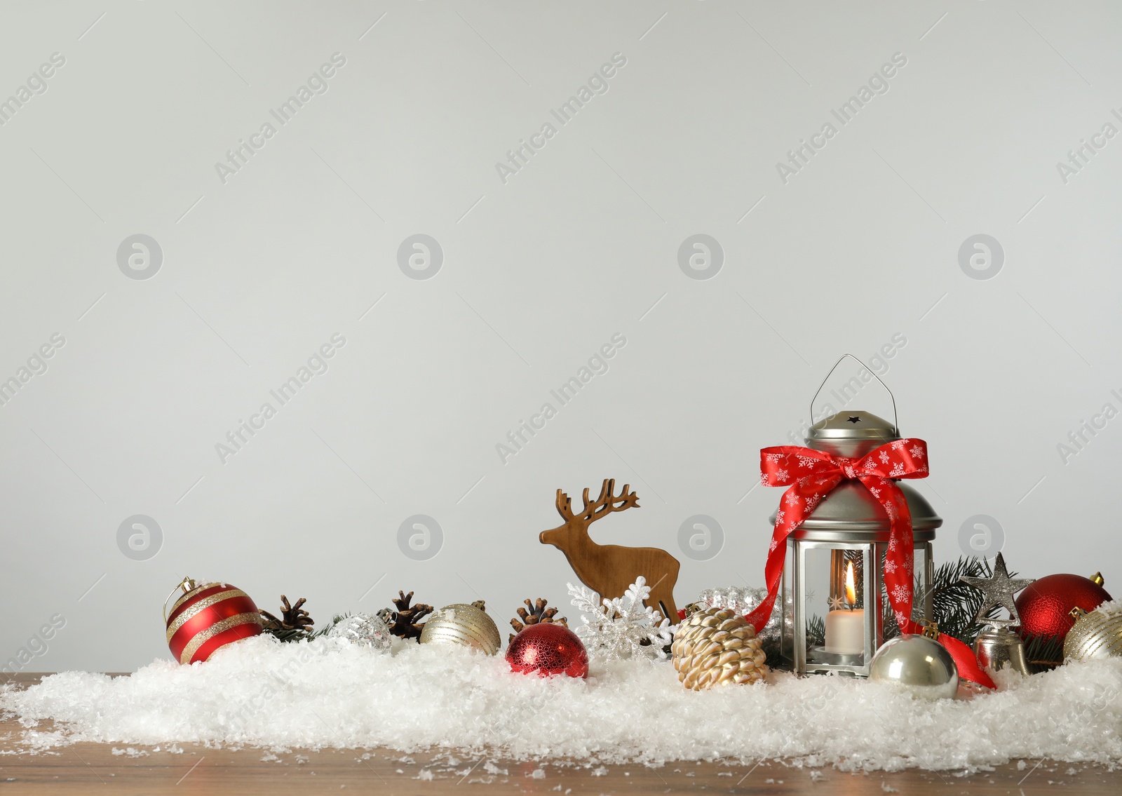 Photo of Beautiful composition with vintage Christmas lantern and festive decorations on snow against white background. Space for text