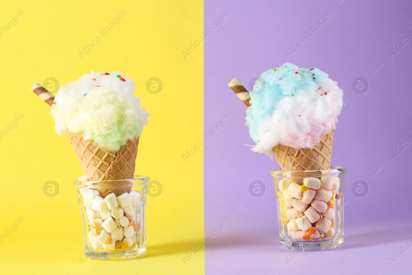 Photo of Sweet cotton candies in waffle cones and marshmallows on color background, closeup