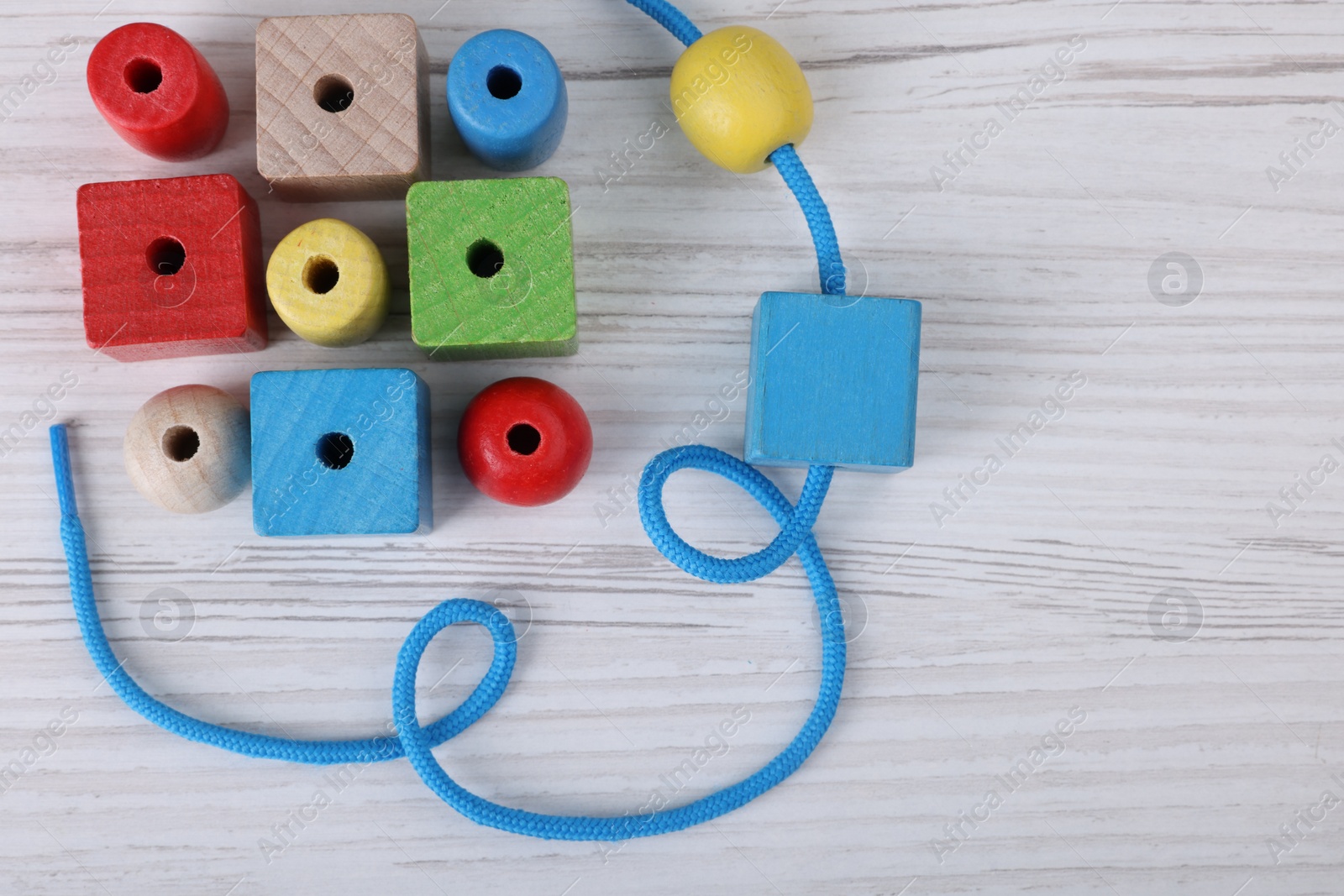 Photo of Wooden lacing toy on light table, top view and space for text. Motor skills development