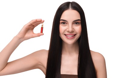 Beautiful young woman holding skincare ampoule on white background