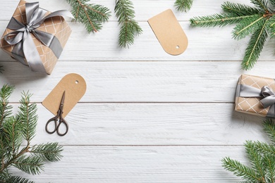 Flat lay composition with Christmas gifts and fir branches on wooden background