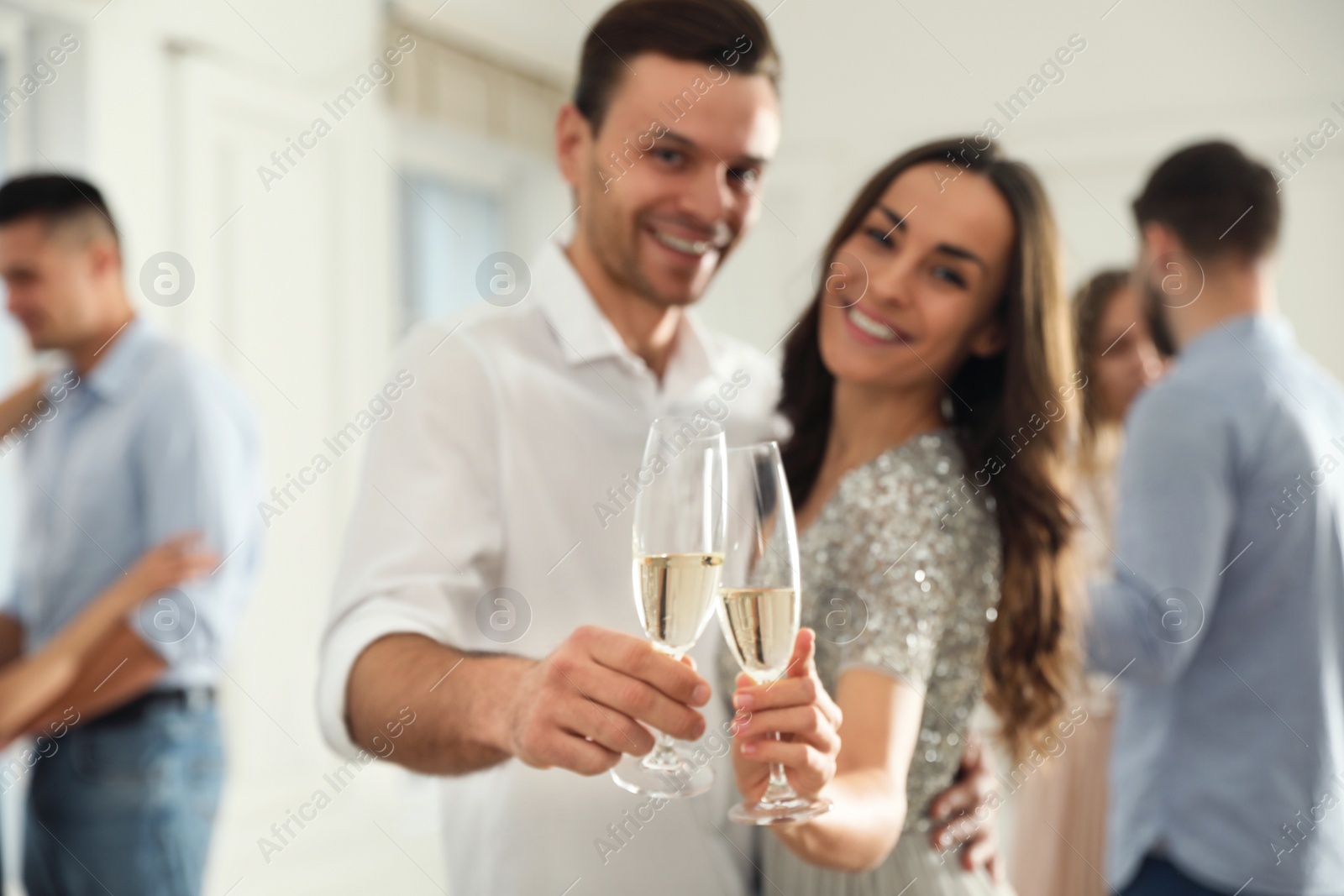 Photo of Lovely young couple with glasses of champagne at dancing party, focus on hands