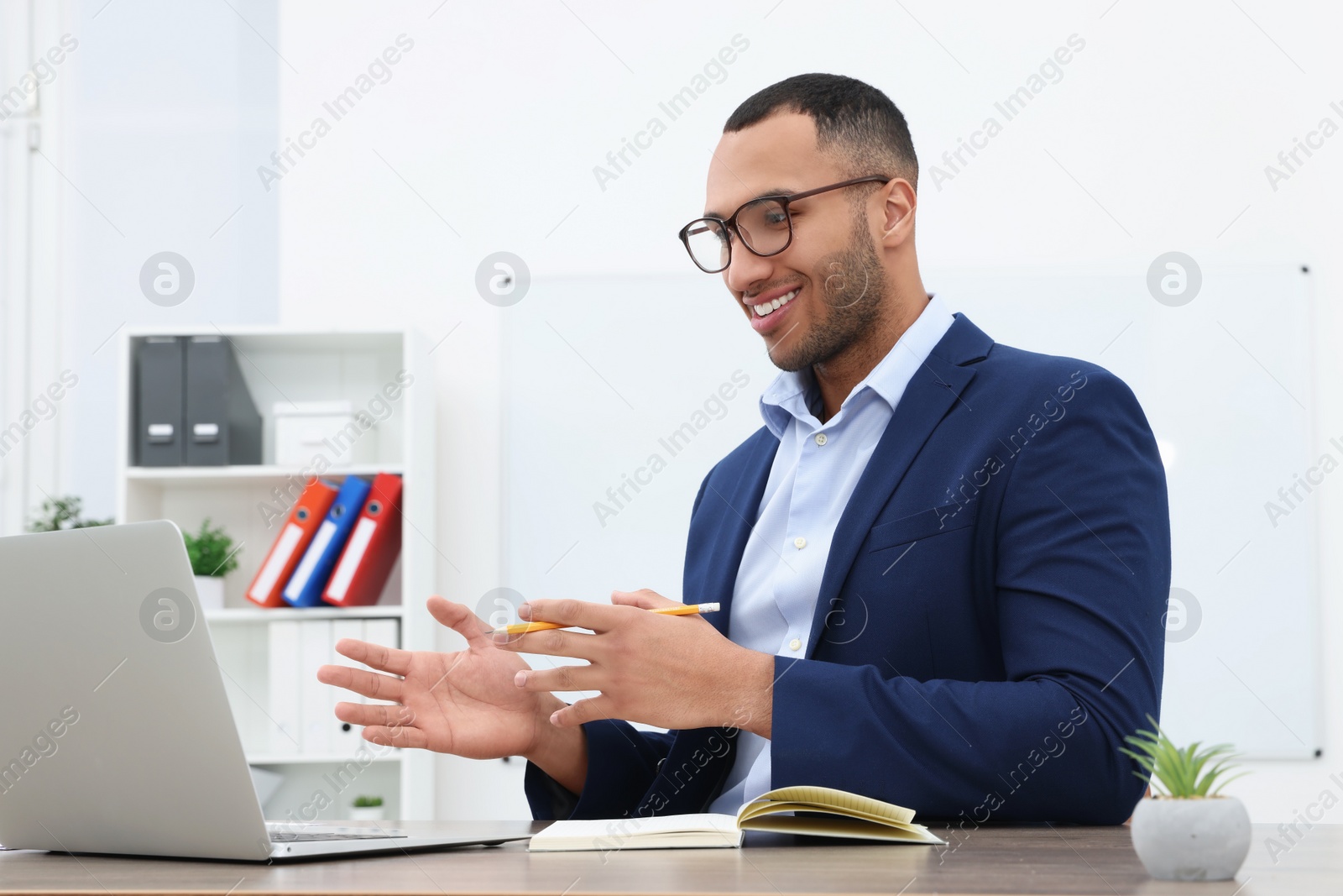 Photo of Happy young intern having online meeting in modern office