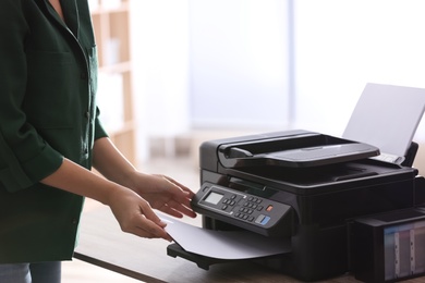 Employee using modern printer in office, closeup