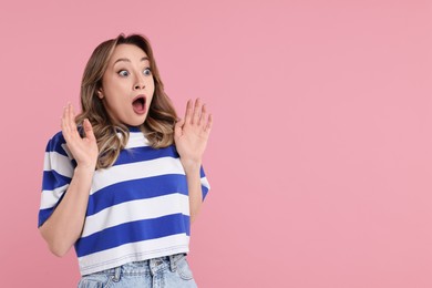 Photo of Portrait of surprised woman on pink background. Space for text