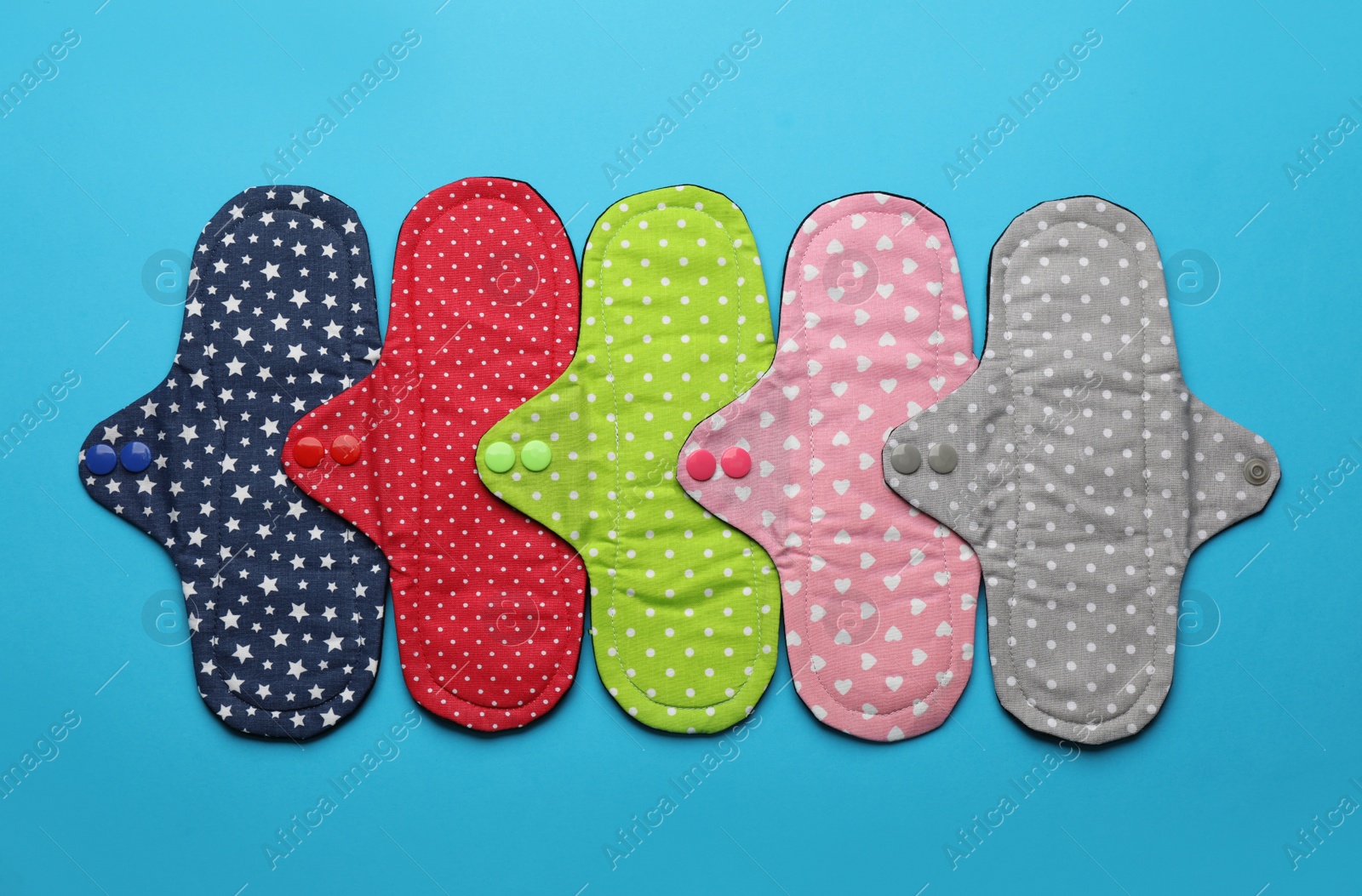 Photo of Many reusable cloth menstrual pads on light blue background, flat lay
