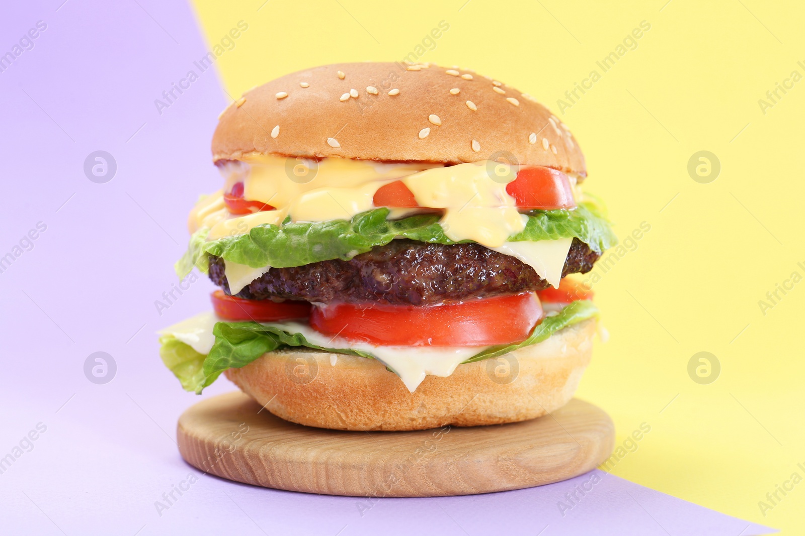 Photo of Burger with delicious patty on color background