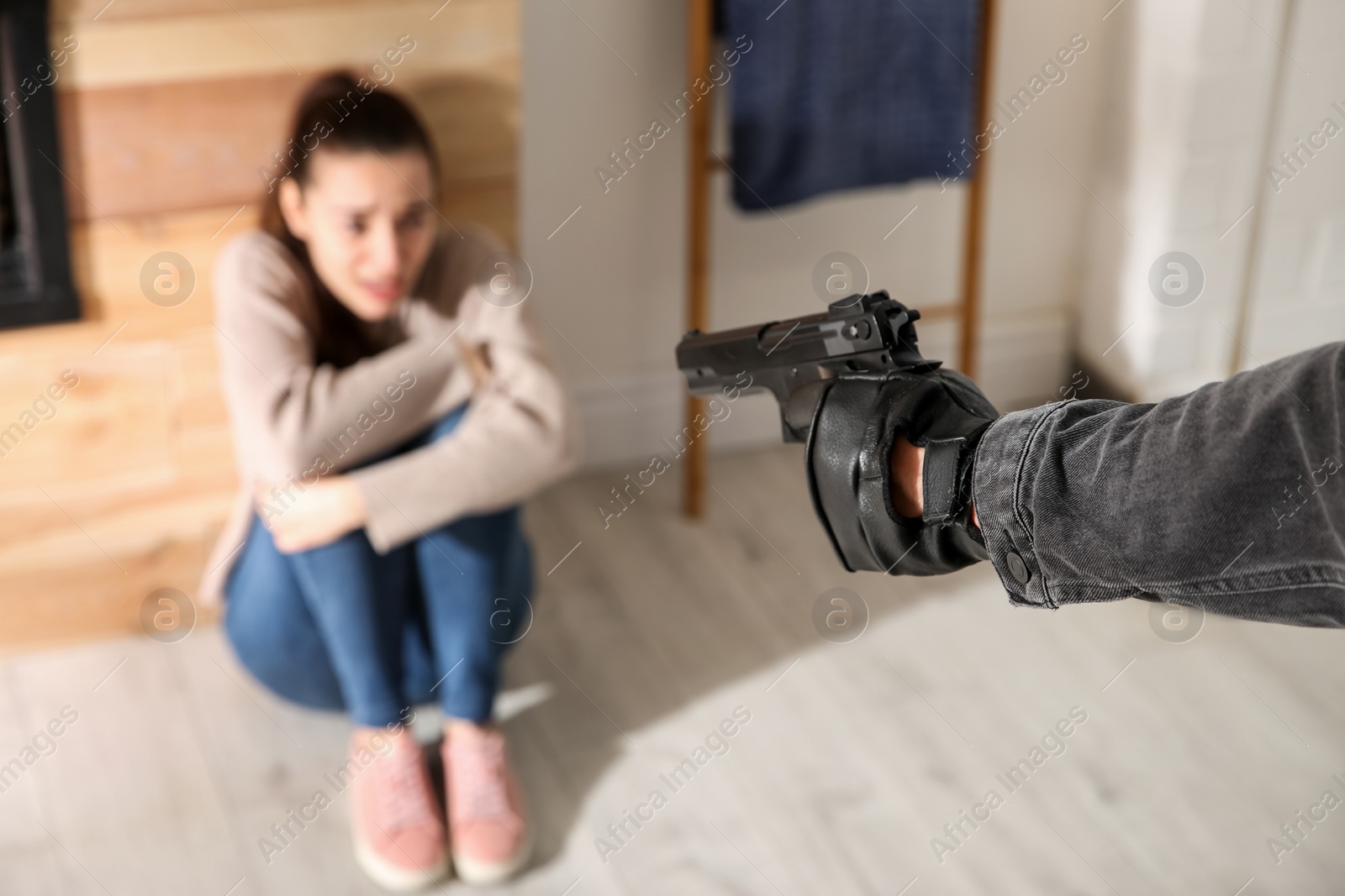 Photo of Man aiming his victim with gun indoors, closeup. Dangerous criminal