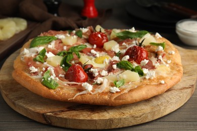 Photo of Pita pizza with prosciutto, pineapple, grilled tomatoes and egg on wooden table, closeup