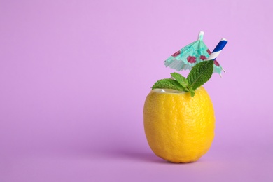 Photo of Creative image of summer cocktail made with lemon, mint, straw and umbrella on color background, space for text