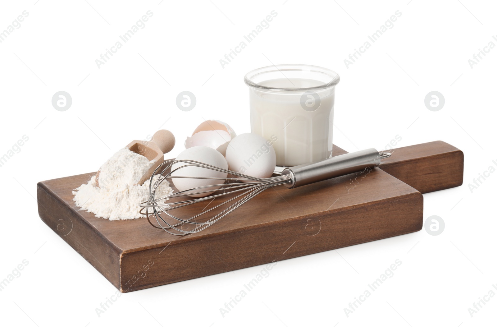 Photo of Board with metal whisk, raw eggs, flour, milk and scoop isolated on white