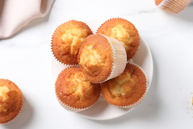 Photo of Delicious sweet muffins on white marble table, flat lay
