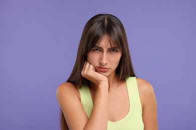 Photo of Portrait of resentful woman on violet background