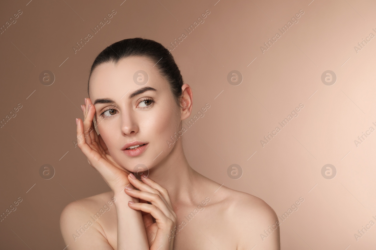 Photo of Portrait of beautiful young woman on light brown background. Space for text