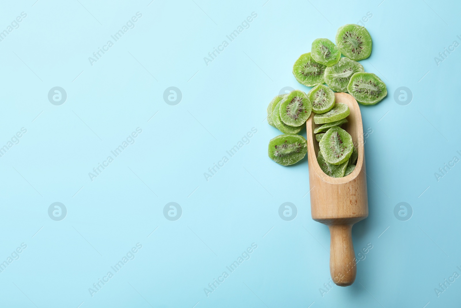 Photo of Scoop of dried kiwi on color background, top view with space for text. Tasty and healthy fruit