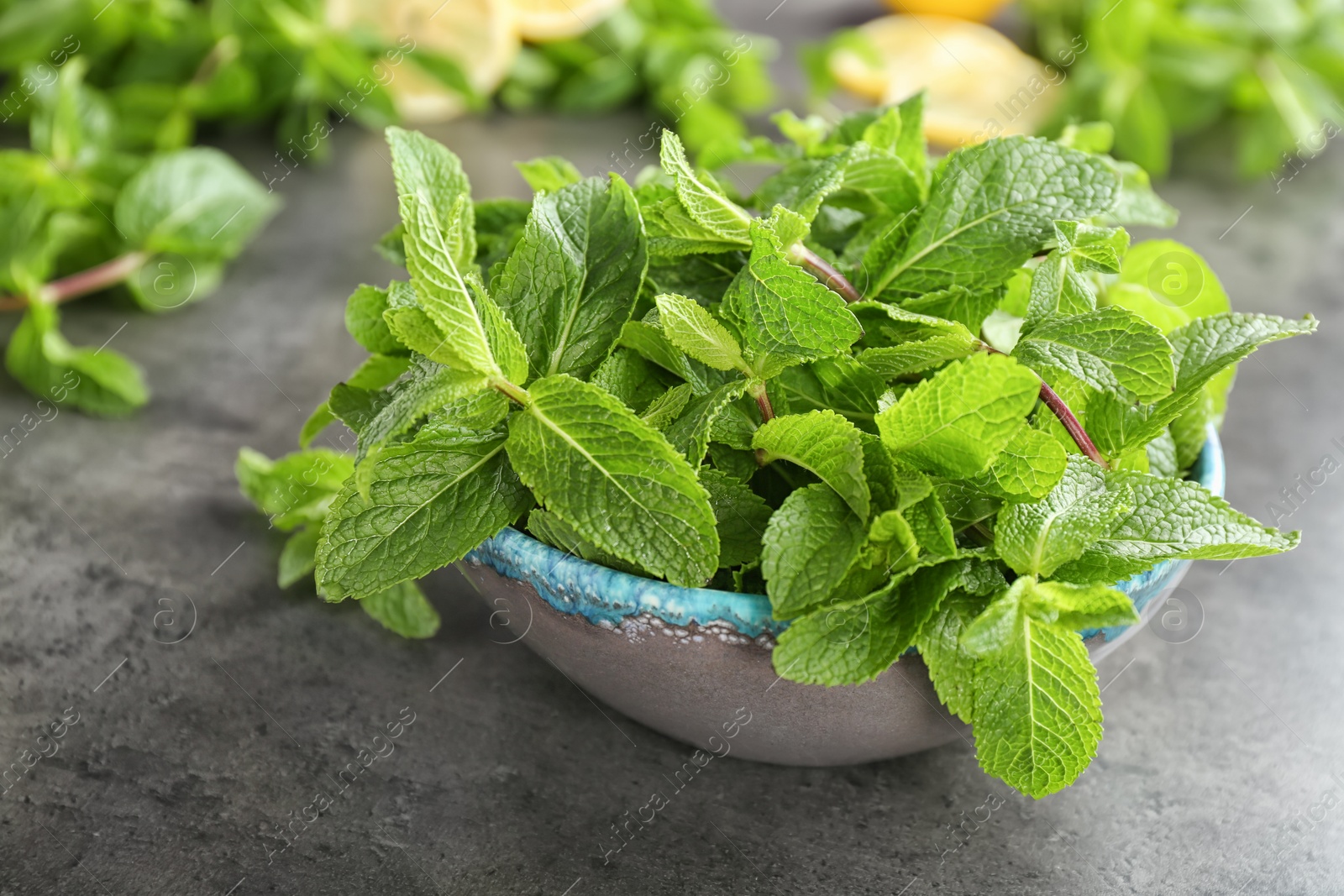 Photo of Bowl with fresh aromatic mint on table