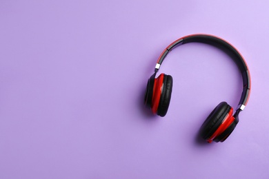 Photo of Wireless headphones on color background, top view. Space for text