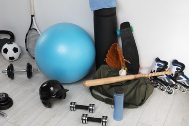 Many different sports equipment near wall indoors