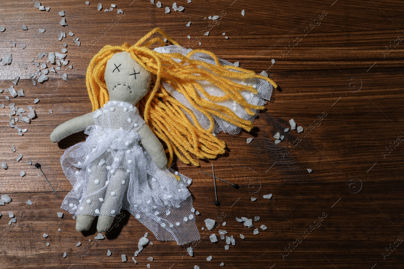 Photo of Bride voodoo doll with pins and salt on wooden background, flat lay