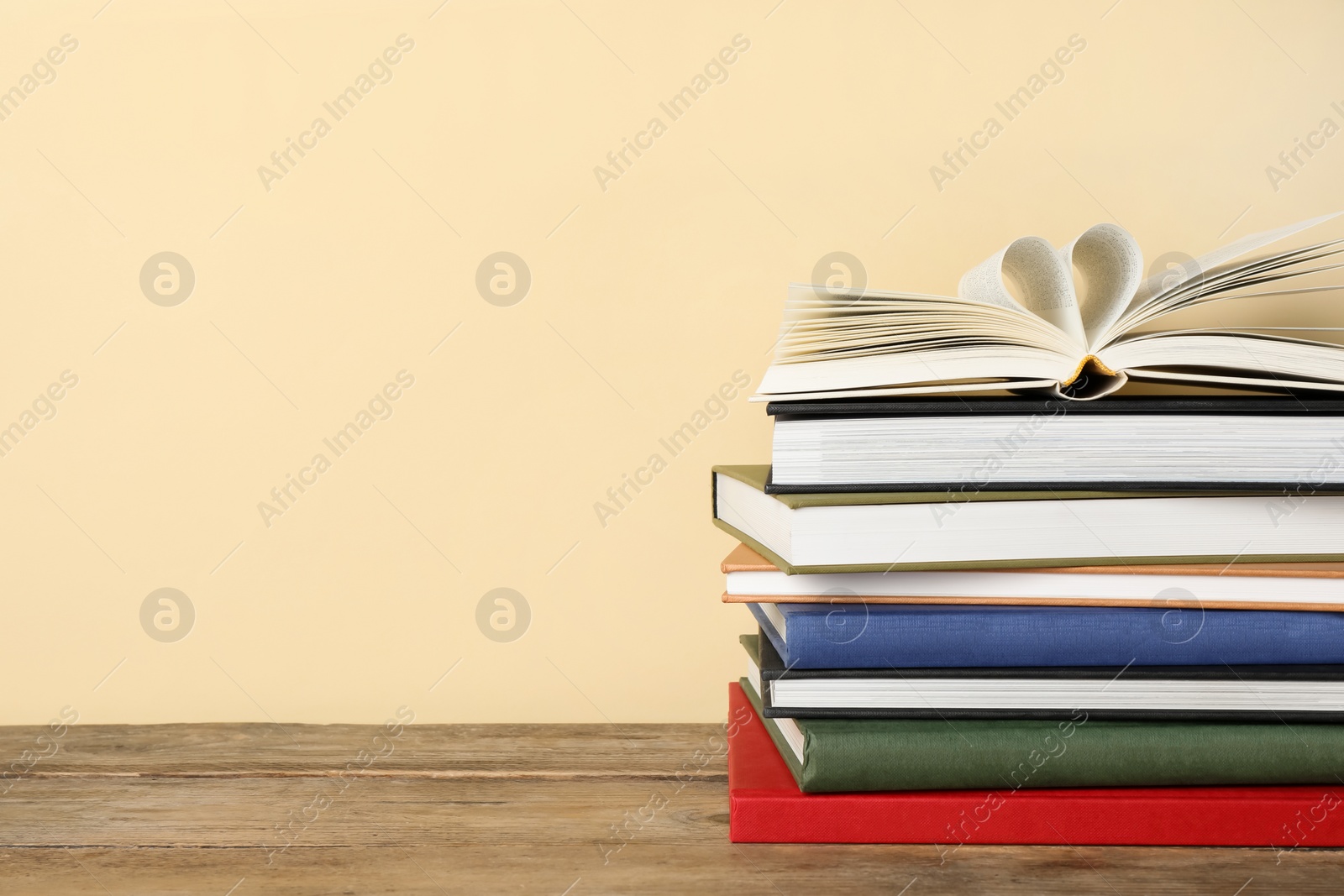 Photo of Stack of hardcover books on wooden table, space for text