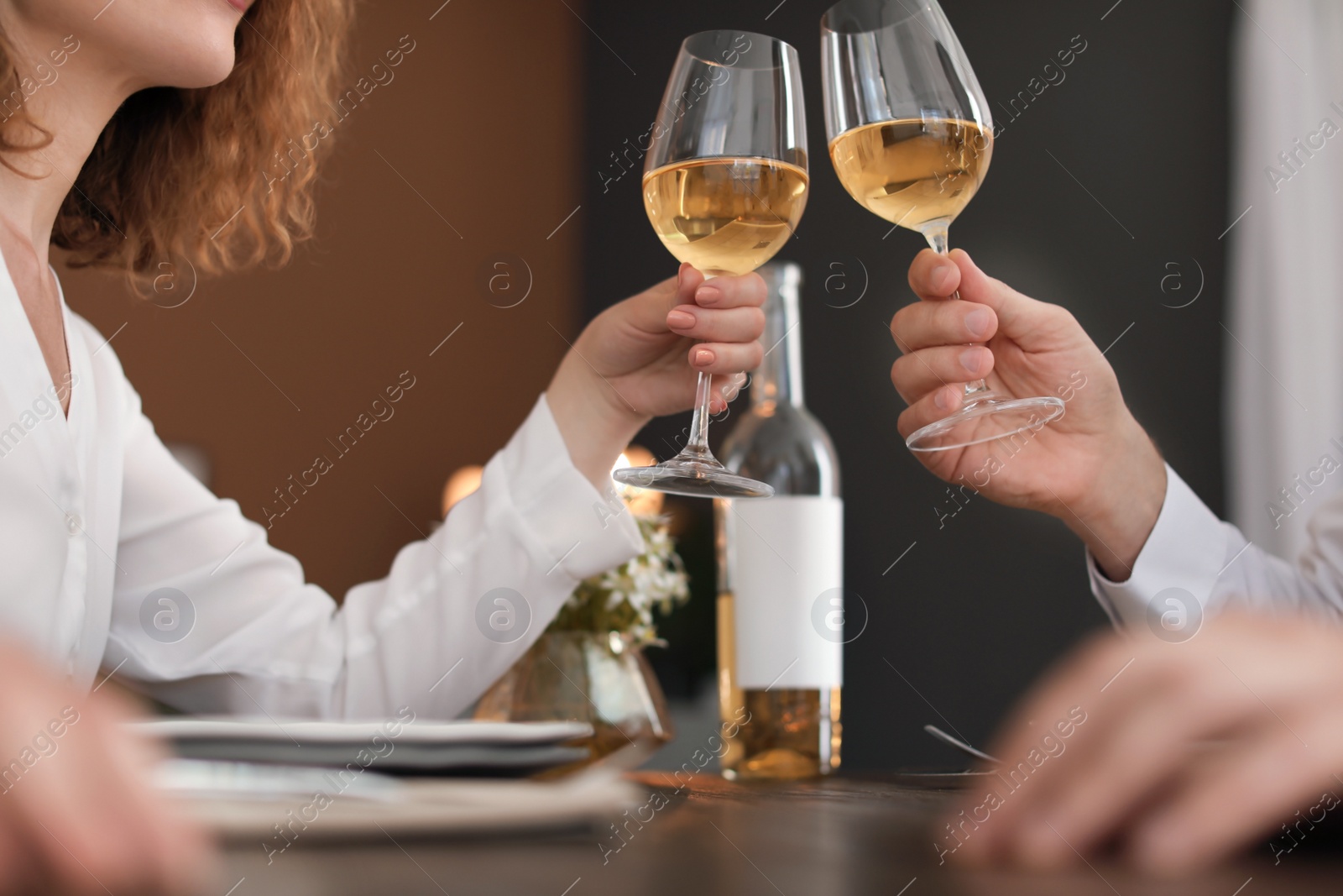 Photo of Young couple with glasses of delicious wine in restaurant