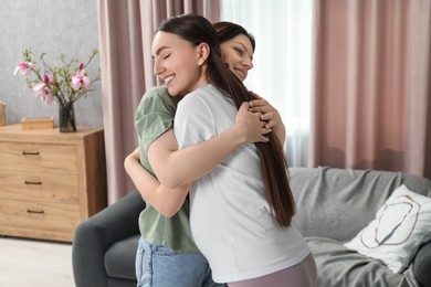 Doula hugging pregnant woman at home. Preparation for child birth