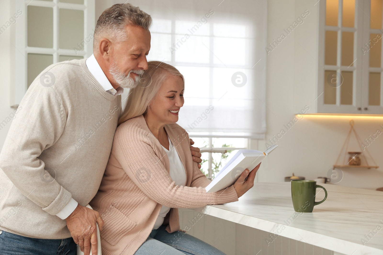 Photo of Happy senior couple spending time together in kitchen