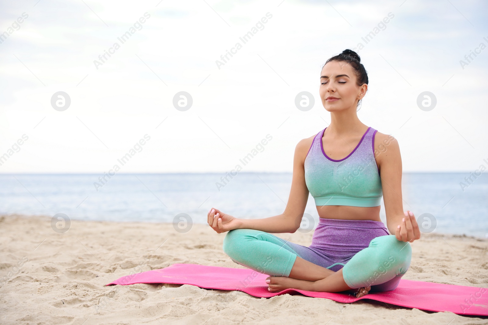 Photo of Young woman practicing yoga on beach, space for text. Body training