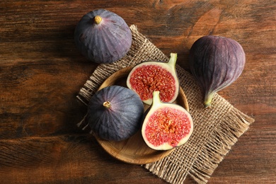 Plate with fresh ripe figs on wooden background, top view