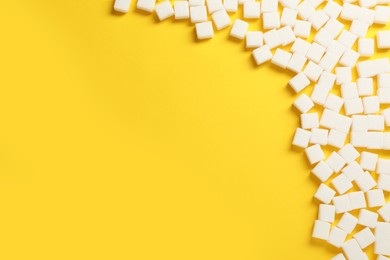 White sugar cubes on yellow background, flat lay. Space for text
