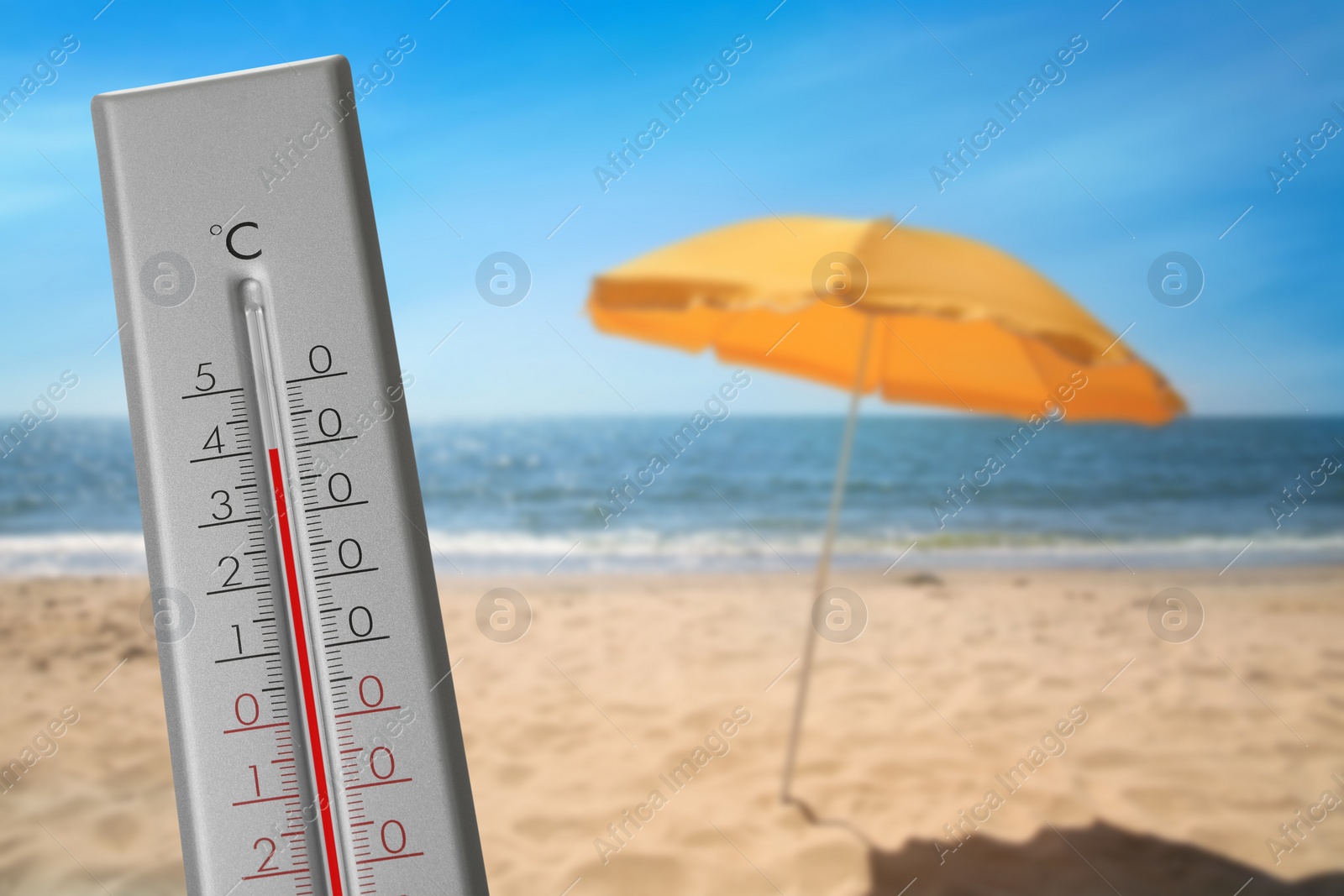 Image of Thermometer on beach showing temperature, summer weather