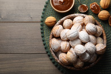 Bowl of delicious nut shaped cookies on wooden table, flat lay. Space for text