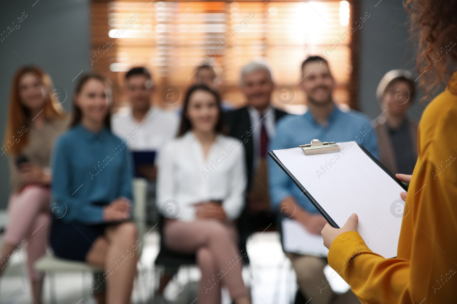 Photo of Business trainer answering questions at seminar in conference hall