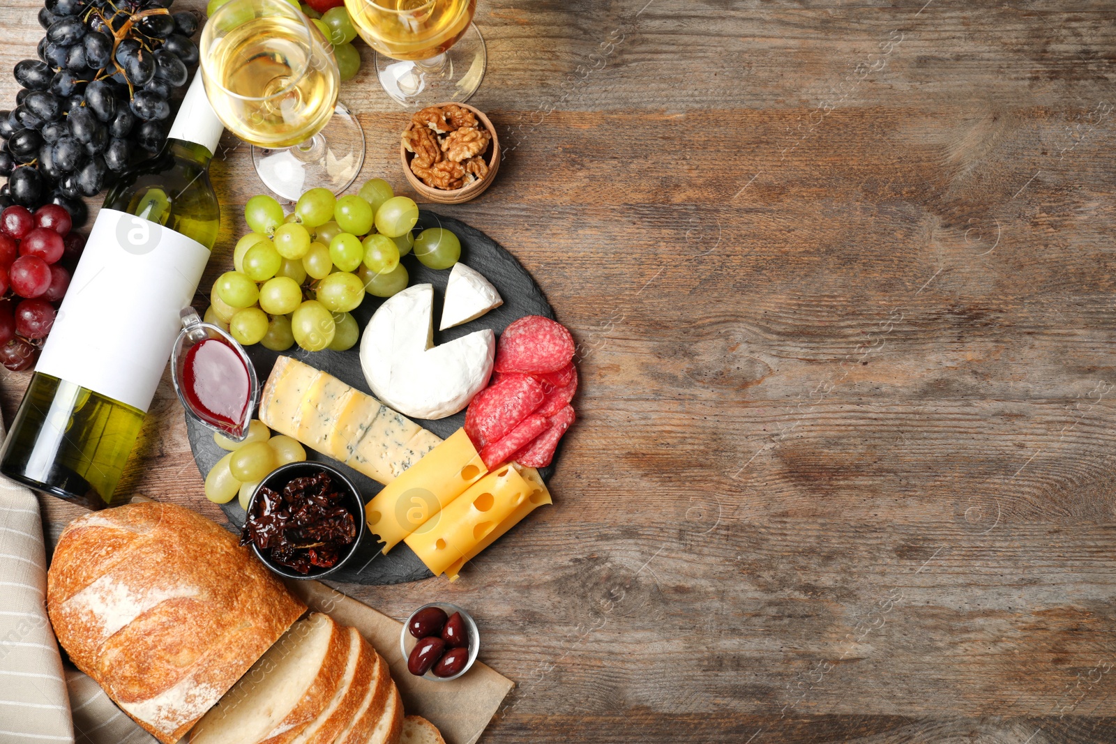 Photo of Flat lay composition with wine, snacks and space for text on wooden background