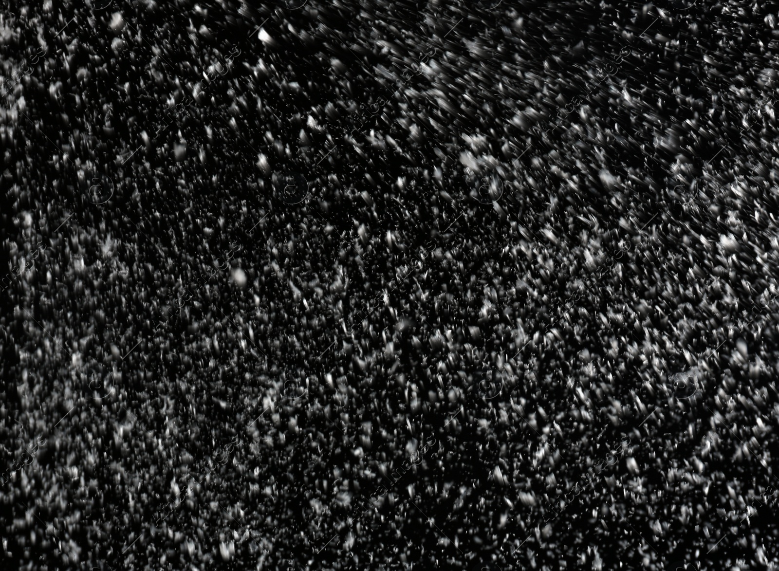 Photo of Snow flakes falling on black background. Winter weather