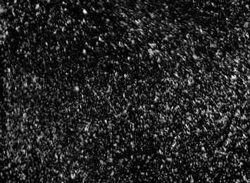 Photo of Snow flakes falling on black background. Winter weather