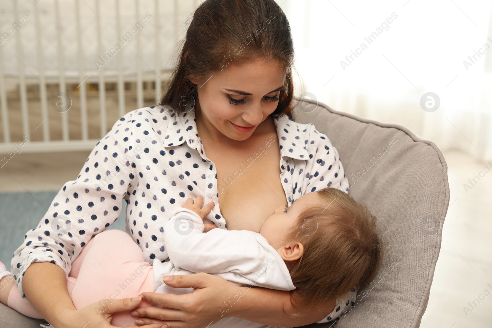 Photo of Woman breastfeeding her little baby at home