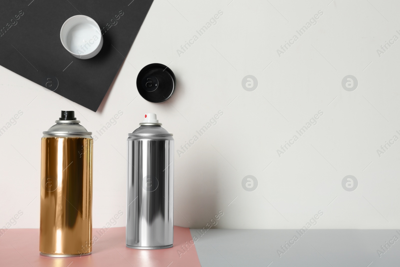 Photo of Cans of different spray paints on color background. Space for text