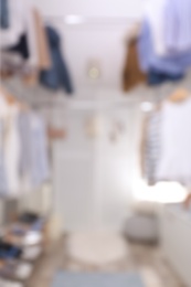 Blurred view of modern dressing room with stylish clothes