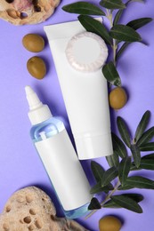 Photo of Different cosmetic products with olives and stones on violet background, flat lay