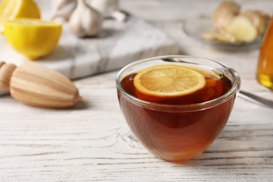 Cup of hot tea with lemon on wooden table, space for text. Cough remedy