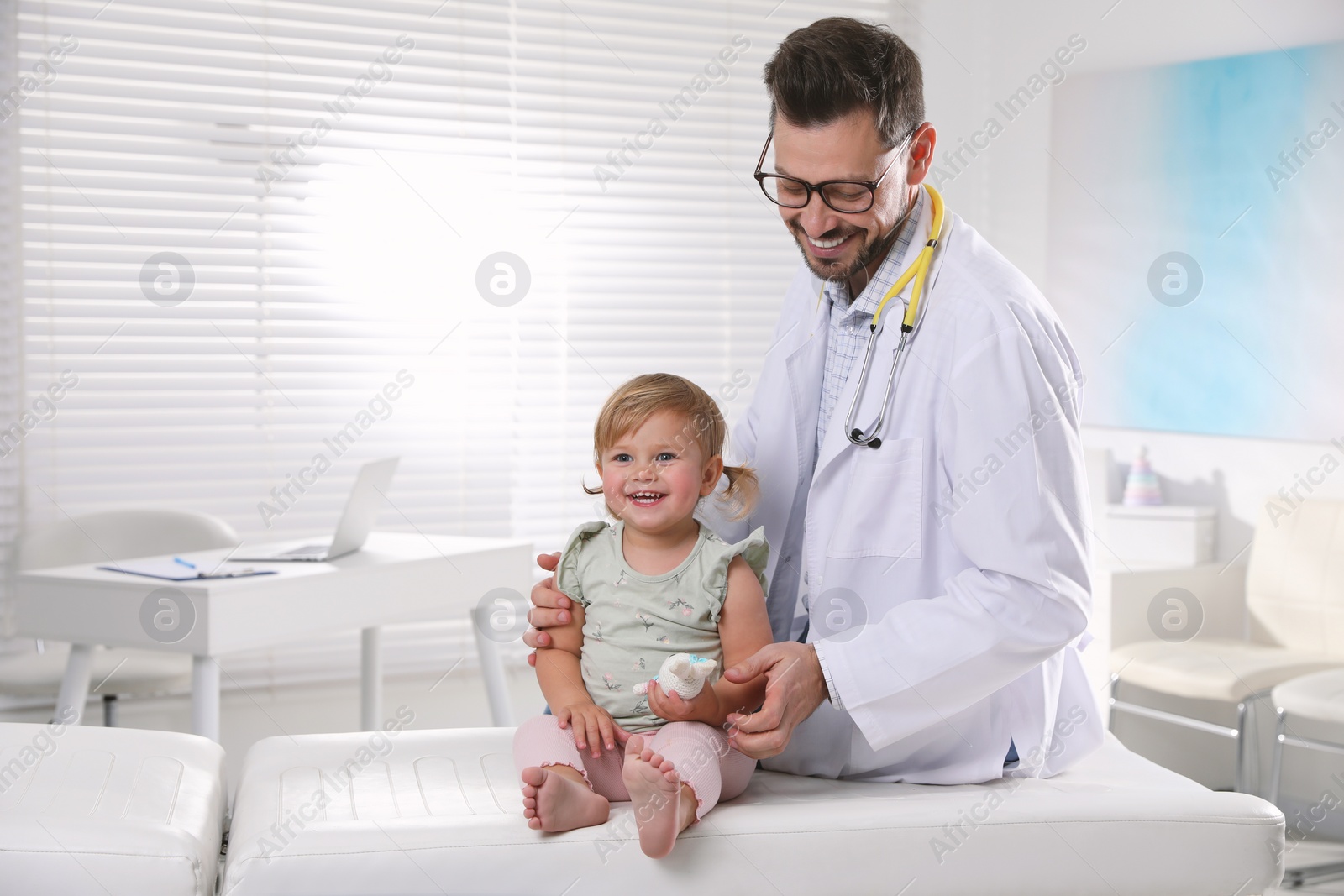 Photo of Pediatrician examining cute little baby in clinic