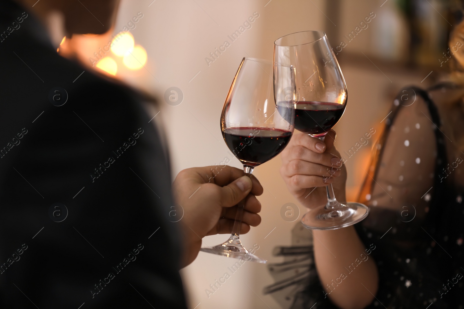 Photo of Couple clinking glasses at Valentine's day dinner in restaurant, closeup